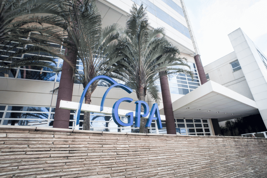 Fachada de prédio do grupo GPA com logo em destaque, rodeada por palmeiras e arquitetura moderna.
