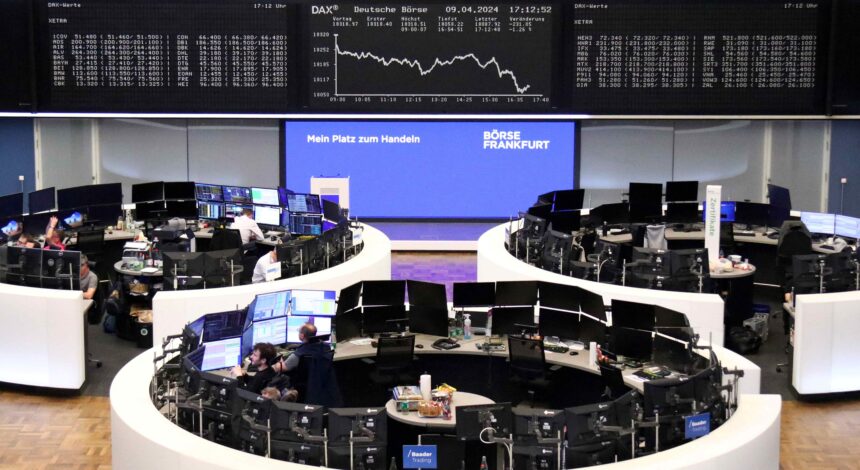 Operadores de bolsa em estações de trabalho na Bolsa de Frankfurt, com múltiplos monitores exibindo dados financeiros em tempo real.