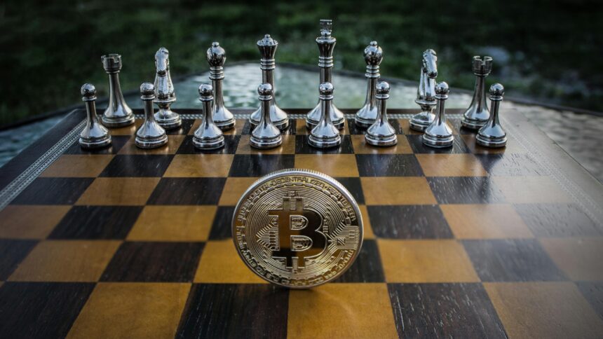 Peças metálicas de xadrez e uma moeda de Bitcoin sobre um tabuleiro, simbolizando a estratégia no investimento em criptomoedas.