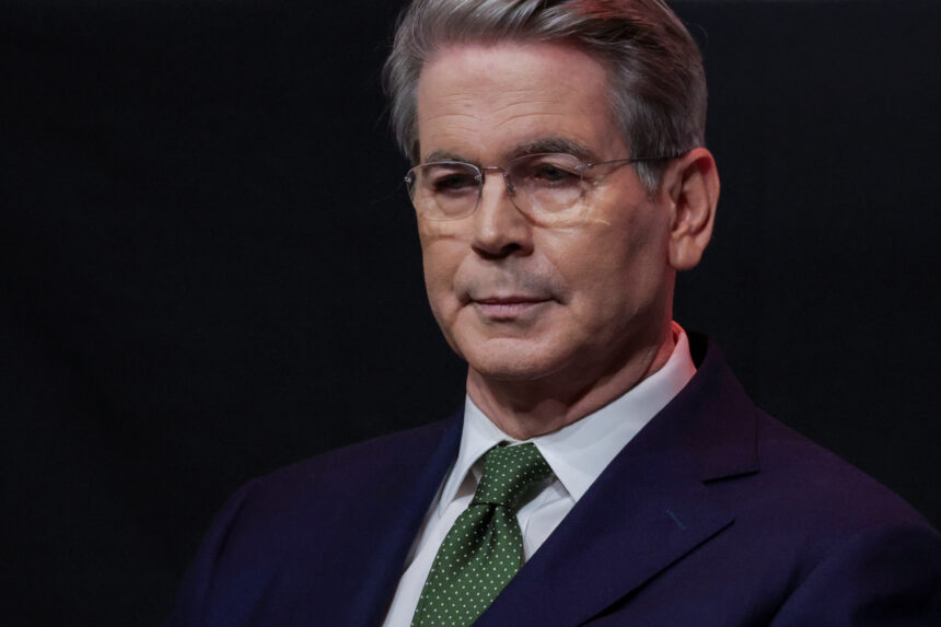 Homem de óculos e terno escuro com gravata verde, olhando seriamente para frente, em fundo preto, transmitindo formalidade.