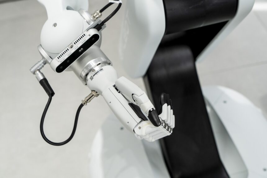 Braço robótico branco em ação com estrutura articulada e sensores avançados, destacando tecnologia de automação industrial.