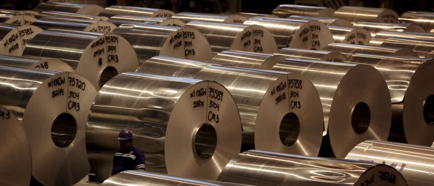 Bobinas de alumínio organizadas em uma fábrica, destacando a produção industrial e a logística de materiais metálicos.