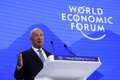 Orador fala em pódio do World Economic Forum, com fundo azul e logotipo do evento. Tema: Davos 2025.