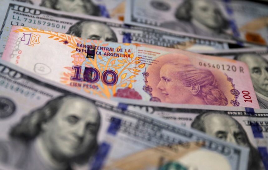 Cédula de 100 pesos argentinos sobre notas de 100 dólares, destacando contraste entre moedas argentina e americana.