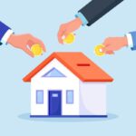 Mãos colocando moedas em miniatura de casa, simbolizando investimento coletivo ou poupança para aquisição imobiliária.