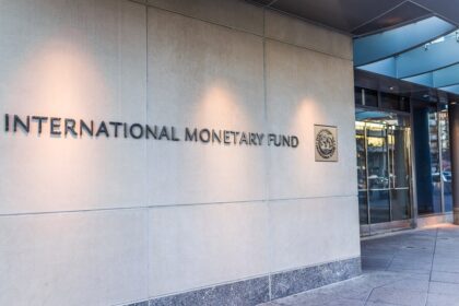 Fachada da sede do Fundo Monetário Internacional, destacando o logotipo e a entrada do edifício.
