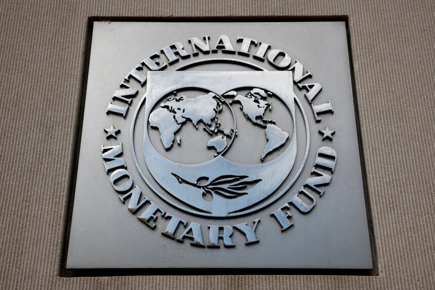 Logotipo do Fundo Monetário Internacional (FMI) em uma placa metálica em um edifício, destacando o mapa-múndi.