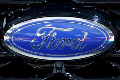 Logo da Ford, fundo azul e contorno cromado, destacando a identidade visual da montadora automobilística.