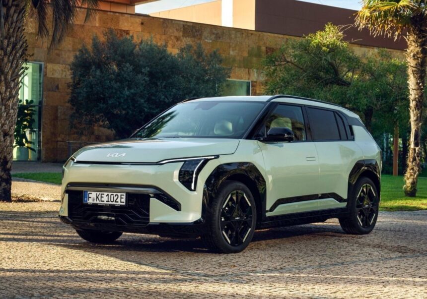 SUV elétrico moderno estacionado em ambiente ao ar livre, rodeado por árvores e edifícios contemporâneos.