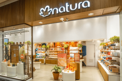 Loja da empresa Natura em um shopping, com produtos expostos e decoração acolhedora, destacando cosméticos e sustentabilidade.