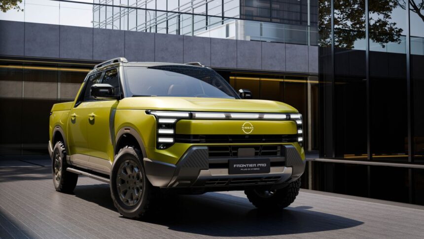 Picape híbrida Nissan Frontier Pro verde, com design robusto, diante de edifício moderno de vidro e concreto.