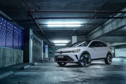 SUV branco estacionado em garagem urbana iluminada, destacando design moderno e linhas esportivas em ambiente industrial.
