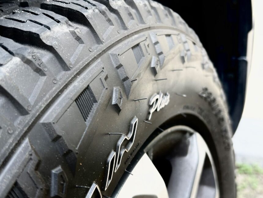 Pneu de carro com foco em detalhes de banda de rodagem robusta, ideal para terrenos acidentados e tração eficiente.