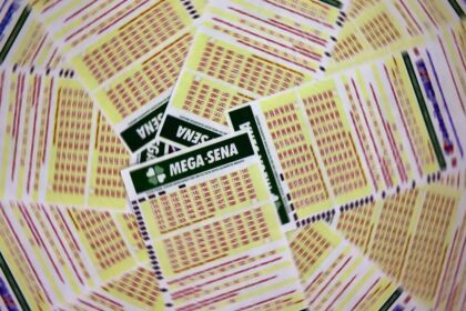 Bilhetes da Mega-Sena espalhados, destacando números e logotipo, representando a expectativa do próximo sorteio.