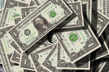 Notas de um dólar múltiplas empilhadas, destacando-se pela presença do retrato de George Washington e detalhes em verde.