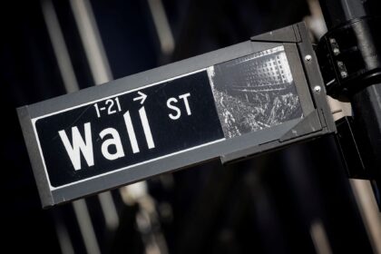 Placa de rua de Wall Street em destaque, símbolo do centro financeiro de Nova York e dos mercados globais.