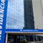 Fachada do prédio da Previdência Social com entrada principal e arquitetura moderna, destacando o nome no letreiro azul.