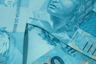 Notas de 100 reais brasileiras empilhadas, destacando detalhes de segurança e design. Ideal para temas sobre economia e finanças.