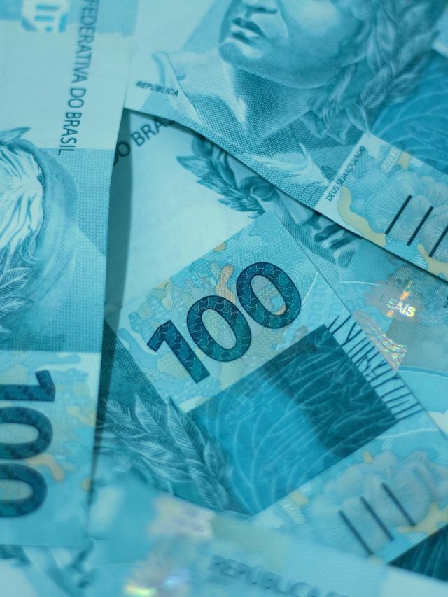 Notas de 100 reais brasileiras empilhadas, destacando detalhes de segurança e design. Ideal para temas sobre economia e finanças.