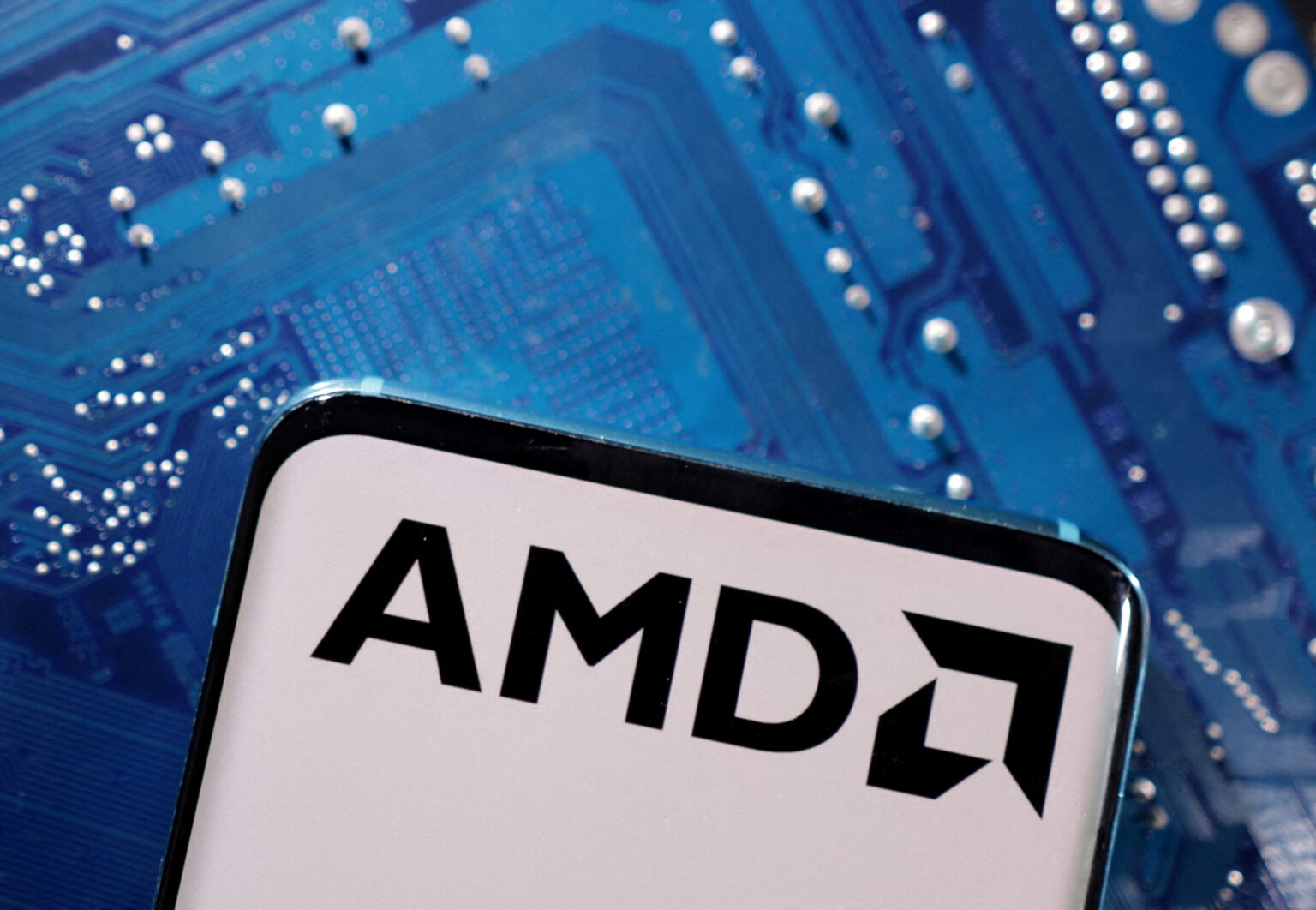 Logotipo da AMD em um fundo de placa-mãe azul, destacando tecnologia de chips e inovação em hardware de computador.