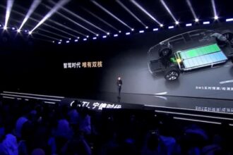 Palco com apresentação sobre tecnologia de baterias automotivas; destaque para imagem técnica projetada em tela grande.