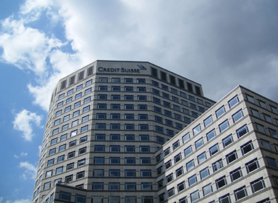 Edifício moderno do Credit Suisse sob um céu parcialmente nublado, representando o setor financeiro global.