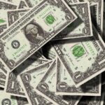 Notas de um dólar dos Estados Unidos sobrepostas, destacando o retrato de George Washington e detalhes em verde.