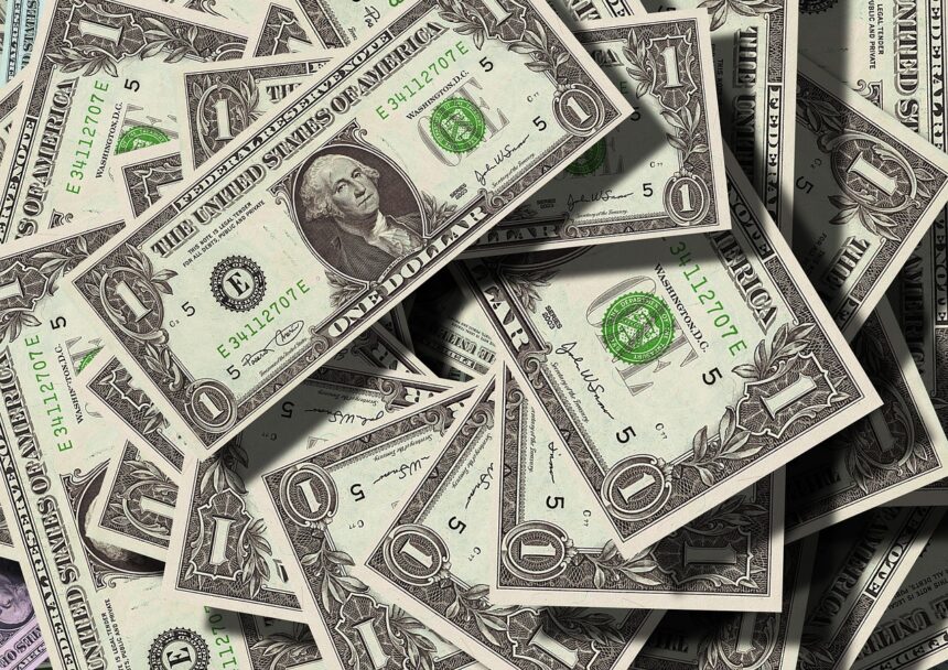 Notas de um dólar dos Estados Unidos sobrepostas, destacando o retrato de George Washington e detalhes em verde.