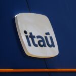 Logotipo do Itaú em fachada azul, destacando a identidade visual do banco com letras brancas em fundo estilizado.
