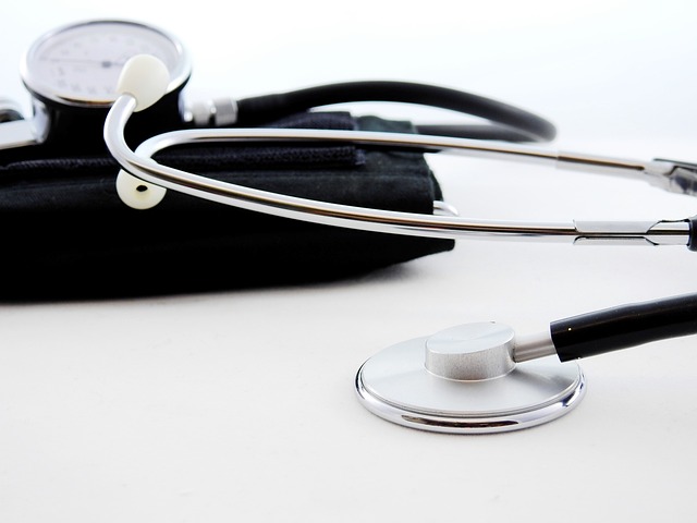 Estetoscópio prateado e aparelho de pressão preto em fundo branco, representando ferramentas de saúde e diagnóstico médico.