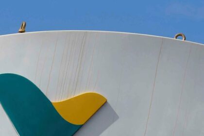 Logotipo da Vale com símbolo verde e amarelo em uma estrutura metálica curvada, destacando indústria e mineração.
