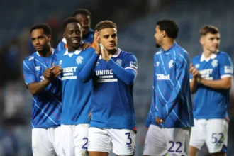 Max Aarons applauds the Rangers fans at the end of a game
