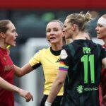 Sydney Lohmann (l., FC Bayern) und Alexandra Popp (2.v.r., VfL Wolfsburg) im hitzigen Austausch, während Schiedsrichterin Fabienne Michel (2.v.l.) dazwischengeht.