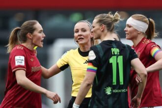 Sydney Lohmann (l., FC Bayern) und Alexandra Popp (2.v.r., VfL Wolfsburg) im hitzigen Austausch, während Schiedsrichterin Fabienne Michel (2.v.l.) dazwischengeht.