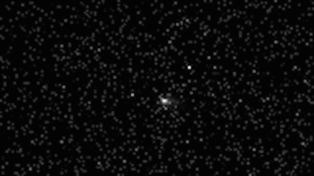 Sonda Tianwen 1 da China registra imagens do cometa 3I/ATLAS black and white photo of a comet, seen as a blurry white orb, in deep space, with fuzzy and distant stars all around
