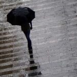 Pedestre se protege da chuva  na região central da cidade de São Paulo, em março deste ano