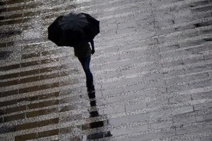 São Paulo em alerta para chuvas e ventos fortes Pedestre se protege da chuva na região central da cidade de São Paulo, em março deste ano