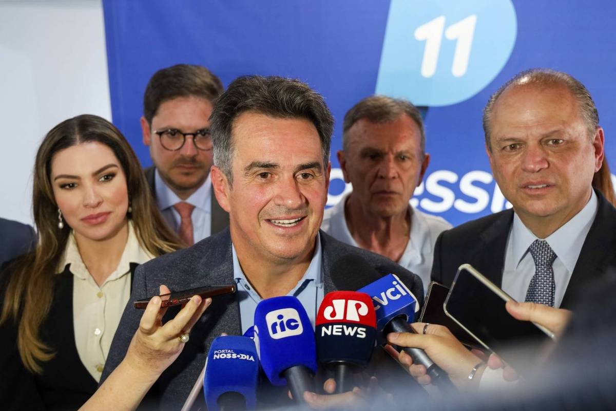 PP no Paraná exclui Sergio Moro da disputa em 2026 Político central fala à imprensa cercado por microfones de várias emissoras, com equipe ao fundo e banner azul com número 11.