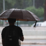 Homem segura guarda-chuva